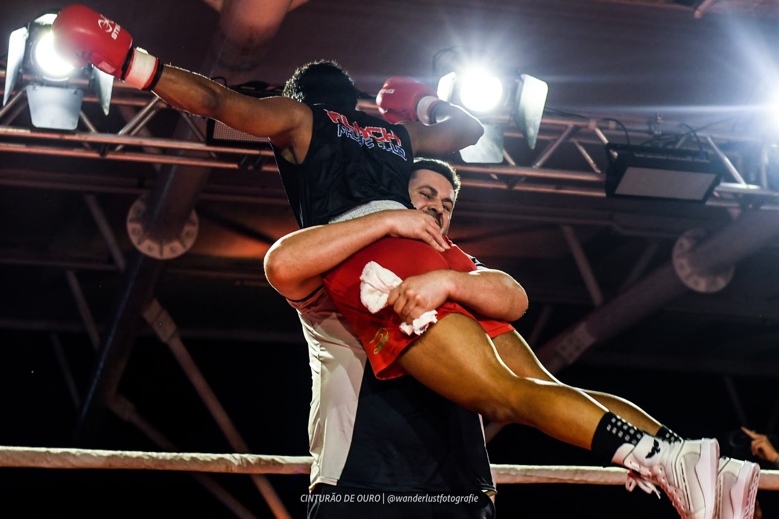 Atleta e treinador celebrando juntos no ringue
